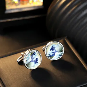 Close-up detail of round glass art cufflinks with classic wave pattern and silver metal.
