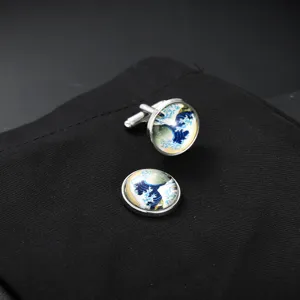 Detailed close-up of round metal cufflinks featuring classic wave art under glass cabochon.