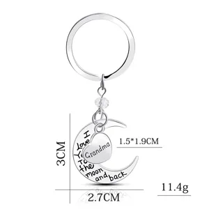 Detailed close-up of the silver moon and heart keychain showing engraved quotes and size.