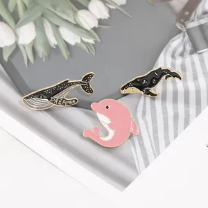 Cute marine animal enamel brooch pins set featuring black whales and a pink dolphin for decor.