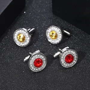 Détail de boutons de manchette en cristal avec des pierres rouges et jaunes et des strass.
