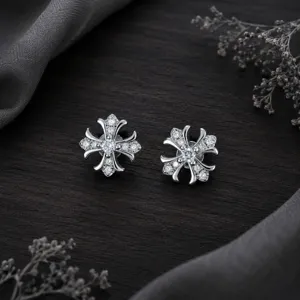 Gros plan sur des boucles d'oreilles croix gothique avec oxydes de zirconium clairs.
