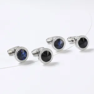 Vue détaillée de boutons de manchette ronds en métal avec oxydes de zirconium bleus et noirs.