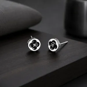 Élégantes boucles d'oreilles trèfle à quatre feuilles avec émail noir et brillant.