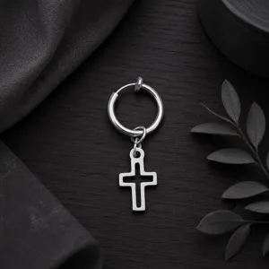 Vue de détail en gros plan d'une boucle d'oreille créole argentée avec pendentif croix.