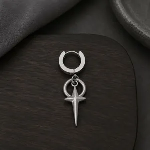 Gros plan sur le détail de la boucles d'oreilles créole pendentif étoile en métal style hip-hop.