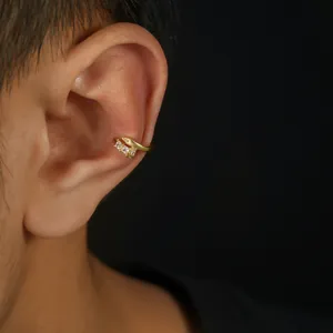 Dettaglio di cuffia per orecchio in zircone dorato, orecchino clip elegante e chic.