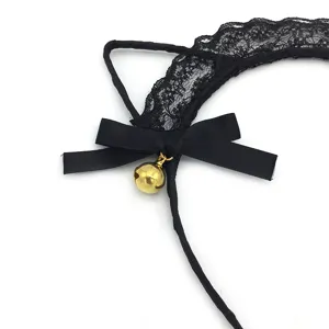 Gros plan du serre-tête oreilles de chat en dentelle noire avec nœud et cloche dorée.