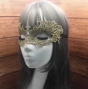 Detalle de la mascara de encaje dorado con bordado complejo y pedreria brillante.