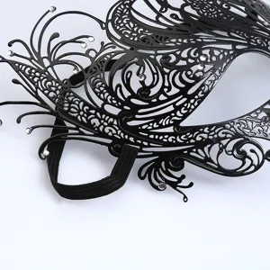 Gedetailleerd zicht op het zwarte metalen masker met fenikspatroon en glinsterende strass.