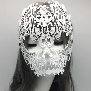 Detailed close up view of white metal skull masquerade mask with dazzling rhinestones.