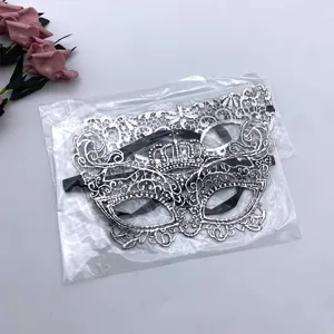 Vista detallada de máscara de encaje plateado con corona, diseño de media cara con cinta negra.