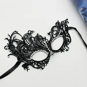 Black lace masquerade mask with rhinestones and ribbon ties, delicate detail shot for party.