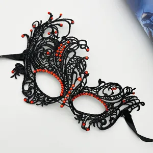 Detailed close-up view of elegant black lace masquerade mask adorned with red rhinestones.