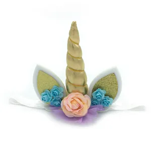 Detailed close-up of gold unicorn horn headband with glitter ears and pastel flowers.