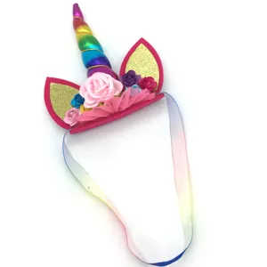 Details of the cute kids unicorn headband with rainbow horn, gold ears and flowers for party.