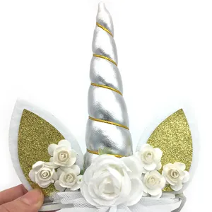 Unicorn headband detail with silver horn, gold glitter ears, and white flowers for party.