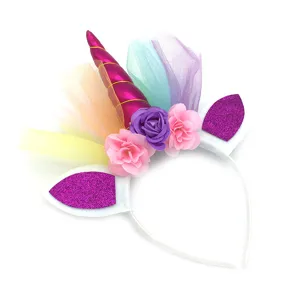 Detail shot of the unicorn headband featuring a pink glitter horn, colorful tulle, and flowers.