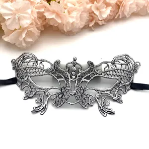 Vista dettagliata dell'elegante maschera in pizzo argentato con intricato design traforato.