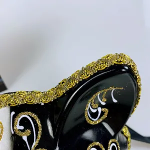 Detailed close-up of a masquerade cat mask with black finish and gold trim texture.