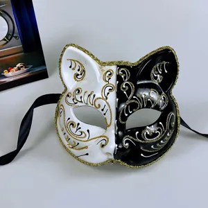 Black and white half face cat mask with gold glitter trim and black ribbon ties for party.