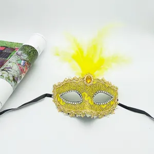 Detail view of yellow masquerade feather mask with lace and rhinestones for party performance.