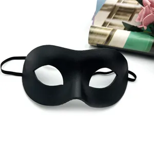 Close-up detail of black leather half-face masquerade party mask with elastic strap.