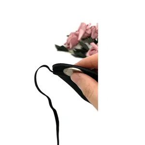 Detail view of black party eye mask showing thickness and elastic strap with soft texture.