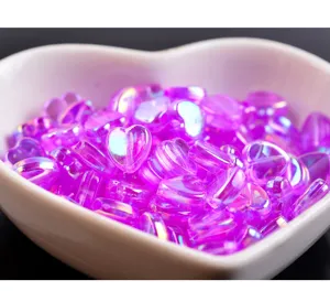 Gros plan de perles en forme de cœur AB violet transparent de 9mm pour la création de bijoux.