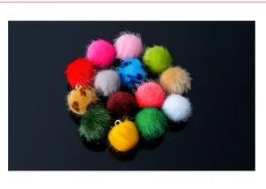 Close-up detail of colorful faux mink fur pom pom charms with metal loops for DIY jewelry.