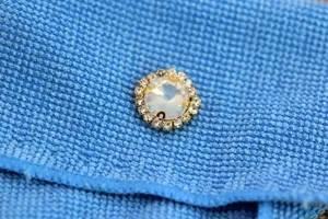 Round sew-on rhinestone crystal button with opalescent center and clear gems for DIY wedding dress.