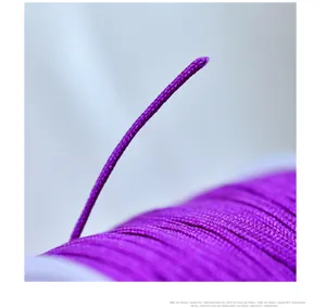 Detalle de cordón trenzado violeta, hilo de alta calidad para joyería y nudos artesanales.