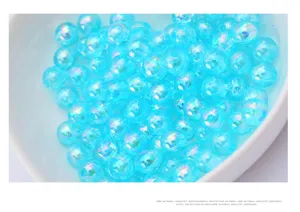 Close-up detail shot of light blue iridescent loose beads, perfect for DIY jewelry crafting.