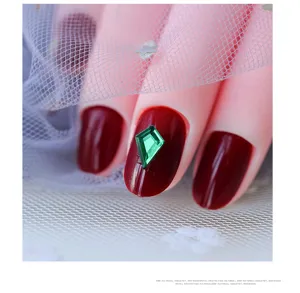 Detalle macro de estrás romboidal verde para una decoración de uñas impresionante y manicura.