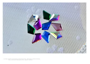 Detalle de pedrería de cristal para uñas con formas geométricas y diseño brillante y colorido.
