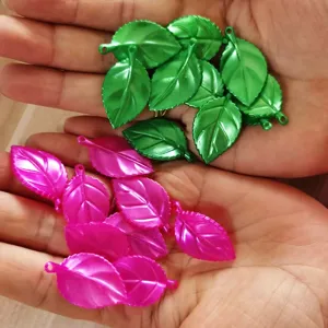 Close-up detail of colorful leaf charms held in hands for DIY craft jewelry making items.