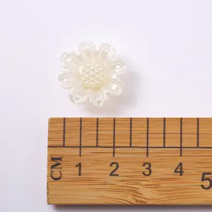 Vue détaillée de l'accessoire bijou fleur perle blanche avec échelle de taille claire.