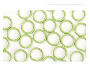 Detail view of green embossed metal jump rings, painted craft connector rings for DIY jewelry.