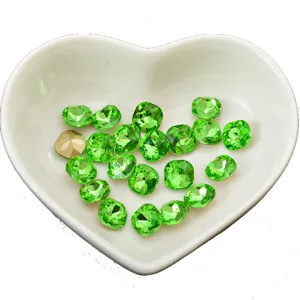 Green pointed-back cushion cut crystal rhinestones in heart dish for DIY nail art.