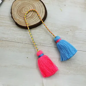 Detailed view of colorful double-headed tassel pendant with braided cord and cotton threads.