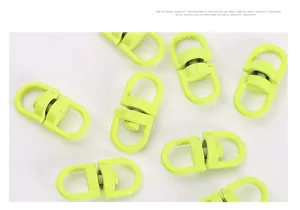 Detailweergave van metalen draaibare karabijnhaak, groene gelakte ring voor sleutelhanger.