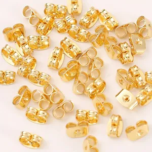 Detailaufnahme verstreuter goldener Ohrringrueckseiten, robuste Metall Ohrstopper fuer Schmuck.