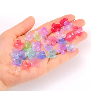 Primer plano de abalorios de flores acrílicas degradadas coloridas para joyería artesanal DIY.
