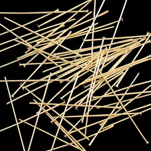 Close-up details of gold jewelry headpins and eye pins for DIY handmade earrings and crafting.