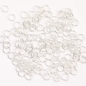 Detalle de anillos de salto de metal plateado, componentes esenciales de joyería DIY para pulseras.