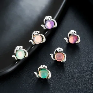 Detailed close-up view of stylized snake ear clips featuring colorful iridescent opal beads.