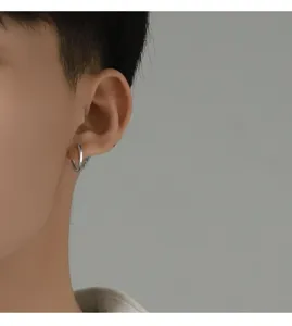 Dettaglio orecchino a cerchio da uomo in argento, design elegante senza piercing per ogni giorno.