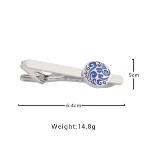 Vue detaillee de pince a cravate en metal argente, motif bleu, accessoire homme elegant.
