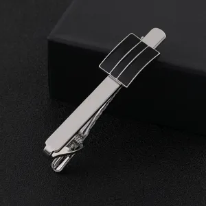 Gros plan detaille d'un elegant pince cravate pour homme argente avec motif noir.