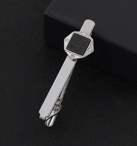 Gros plan detail de la pince a cravate geometrique pour homme argente avec des strass brillants.